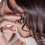 Pag 16 Pagina piena scontornata con Qr code in basso a destra sulla camicia bianca. Earings scritto sull’immagine in nero